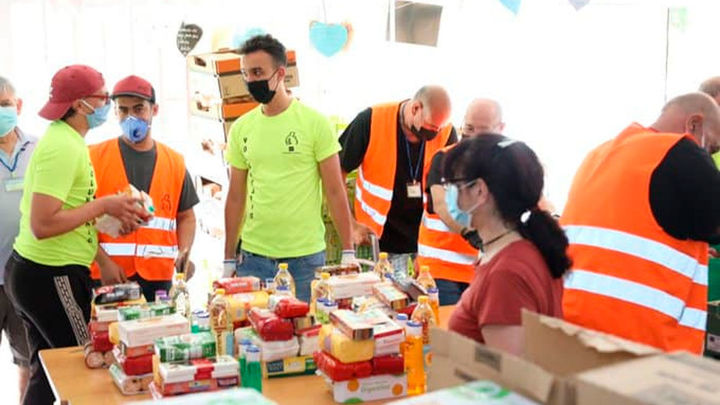 Voluntarios organizan la entrega de alimentos en una despensa solidaria / Telemadrid.es