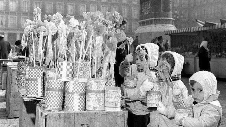 Niños probando zambombas en los puestos de la Plaza Mayor de Madrid. Años 60. / Autor desconocido