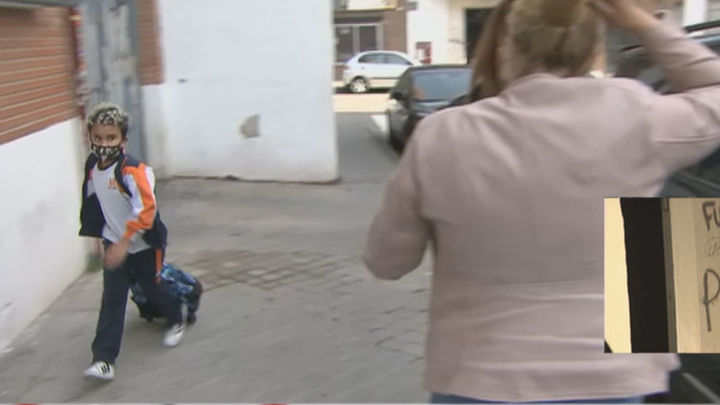Un niño pasa a la carrera para ir al cole al lado de una okupa de la calle José Garrido / TELEMADRID