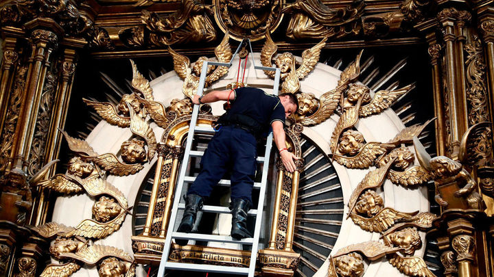 Los bomberos bajan la imagen de la Virgen de la Paloma / EFE