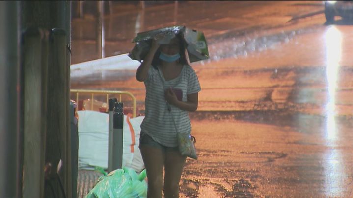 Una mujer se refugia de la lluvia en Madrid / TELEMADRID