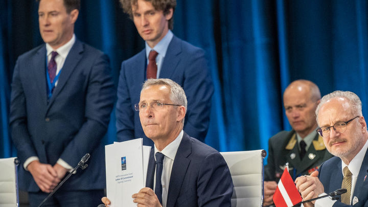 El Secretario General de la OTAN, Jens Stoltenberg (C), sostiene la Carta de compromiso del Fondo de Innovación de la OTAN durante la ceremonia de firma. / EUROPA PRESS