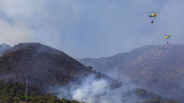 Dos helicópteros del servicio de bomberos trabajan en el incendio declarado en la sierra de Mijas, Málaga / EFE