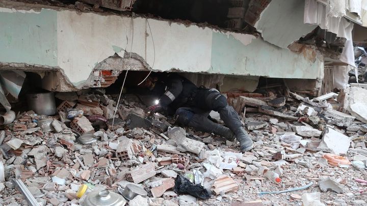 Un miembro de los equipos de rescate españoles inspecciona un edificio derrumbado en Hatay (Turquía) / EFE