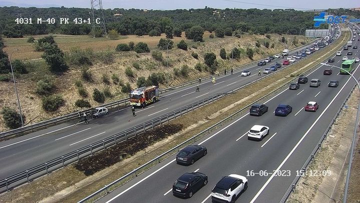 Imagen del vehículo incendiado y del atasco que provocó el suceso / DGT
